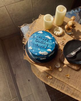 A whimsical sky-themed birthday cake with candles and rustic decor, perfect for birthdays.