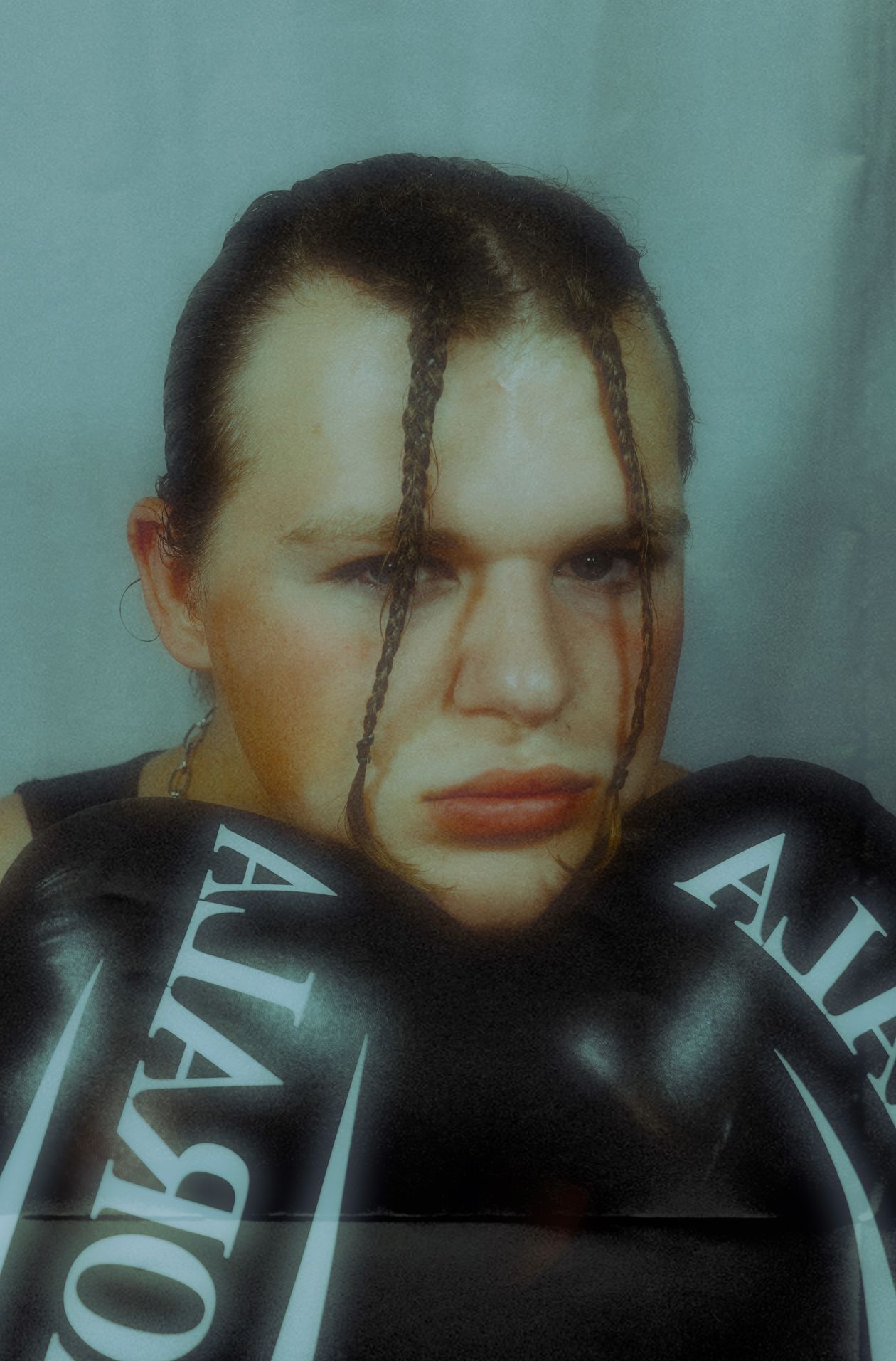 Retrato concentrado de un boxeador con guantes cerca del rostro.