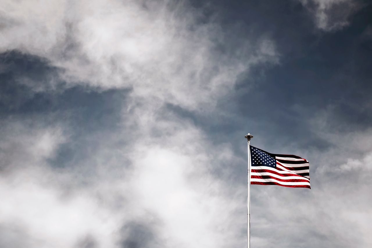 vibrant american flag waving against a striking cloudy sky symbolizing