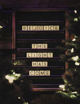 一个写着“欢乐，光明来了”的字母板特写，周围环绕着节日的灯光