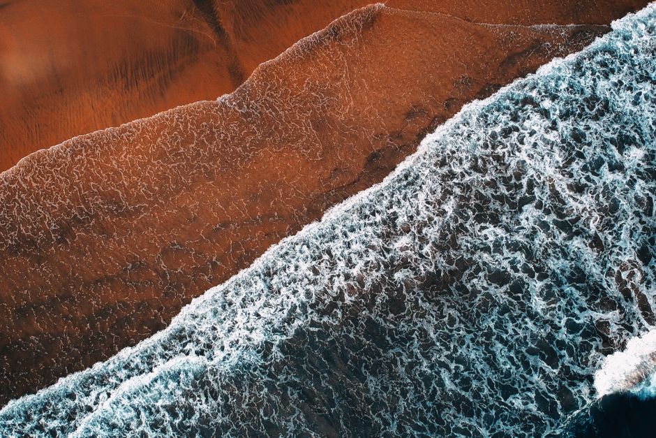 Stunning aerial shot of waves crashing on the sandy shore in Terengganu, Malaysia.