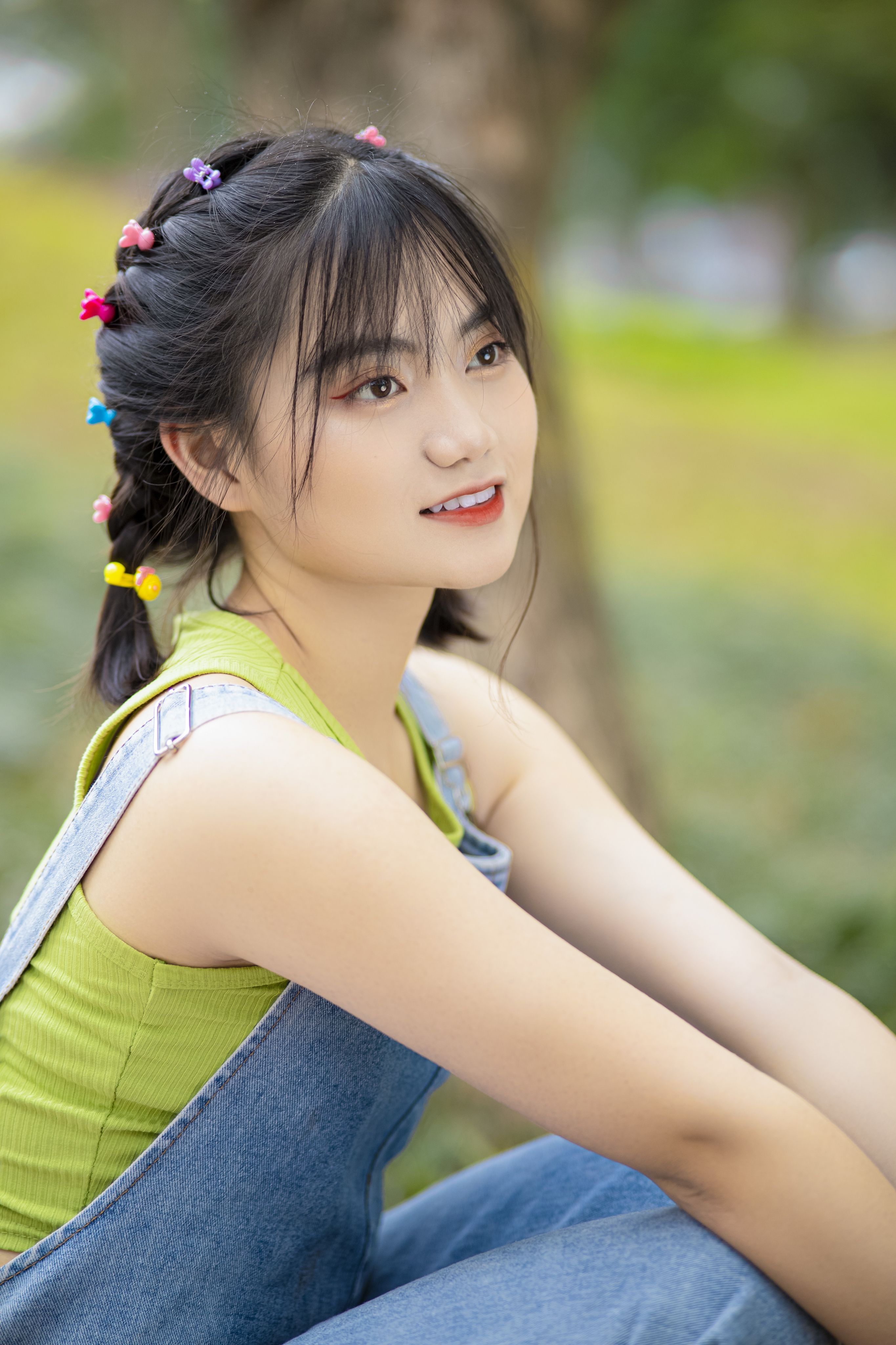 Beautiful young woman enjoying a sunny day outdoors, smiling gently.