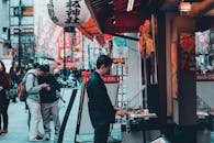 日本热闹的街头市场上挂着纸灯笼，人们正在购物