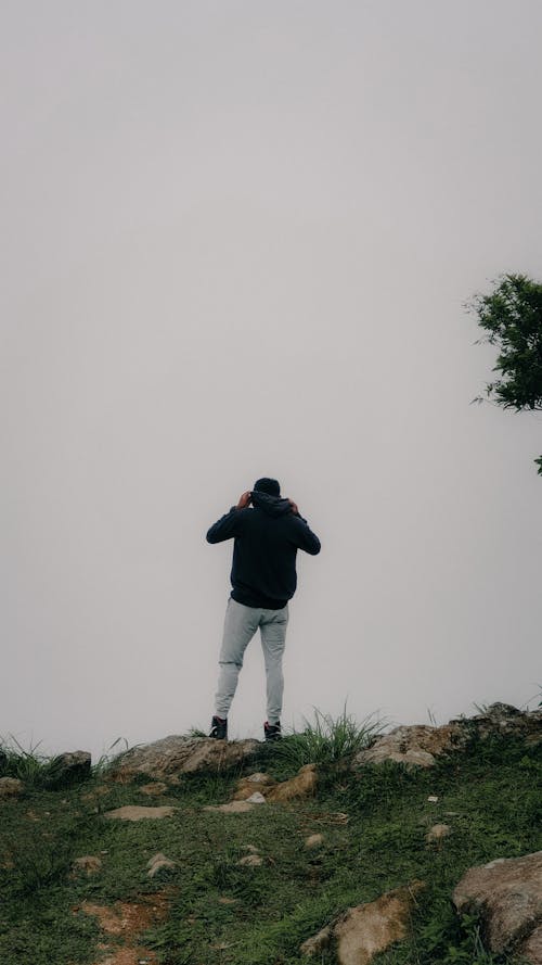Man in Hoodie Standing on Hill