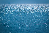 宁静的海景，波光粼粼的海水反射阳光，创造出散景效果