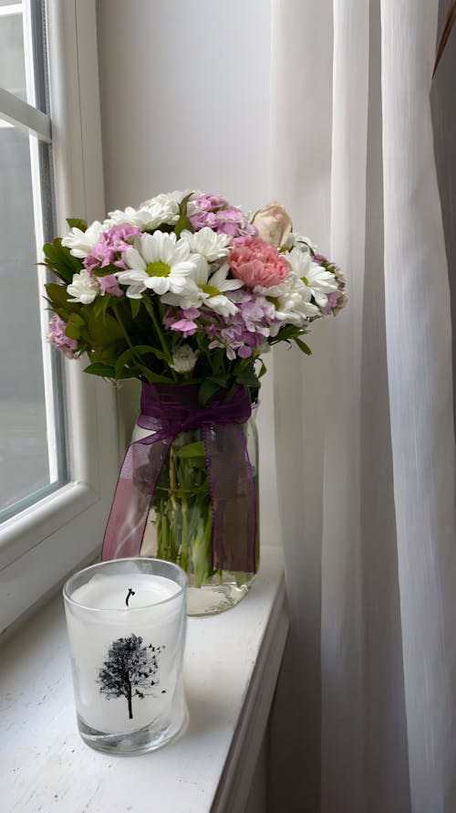 Flowers and Wax Candle on Windowsill