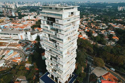 Aerial shot of a modern architectural tower standing amidst the cityscape of São Paulo, Brazil.