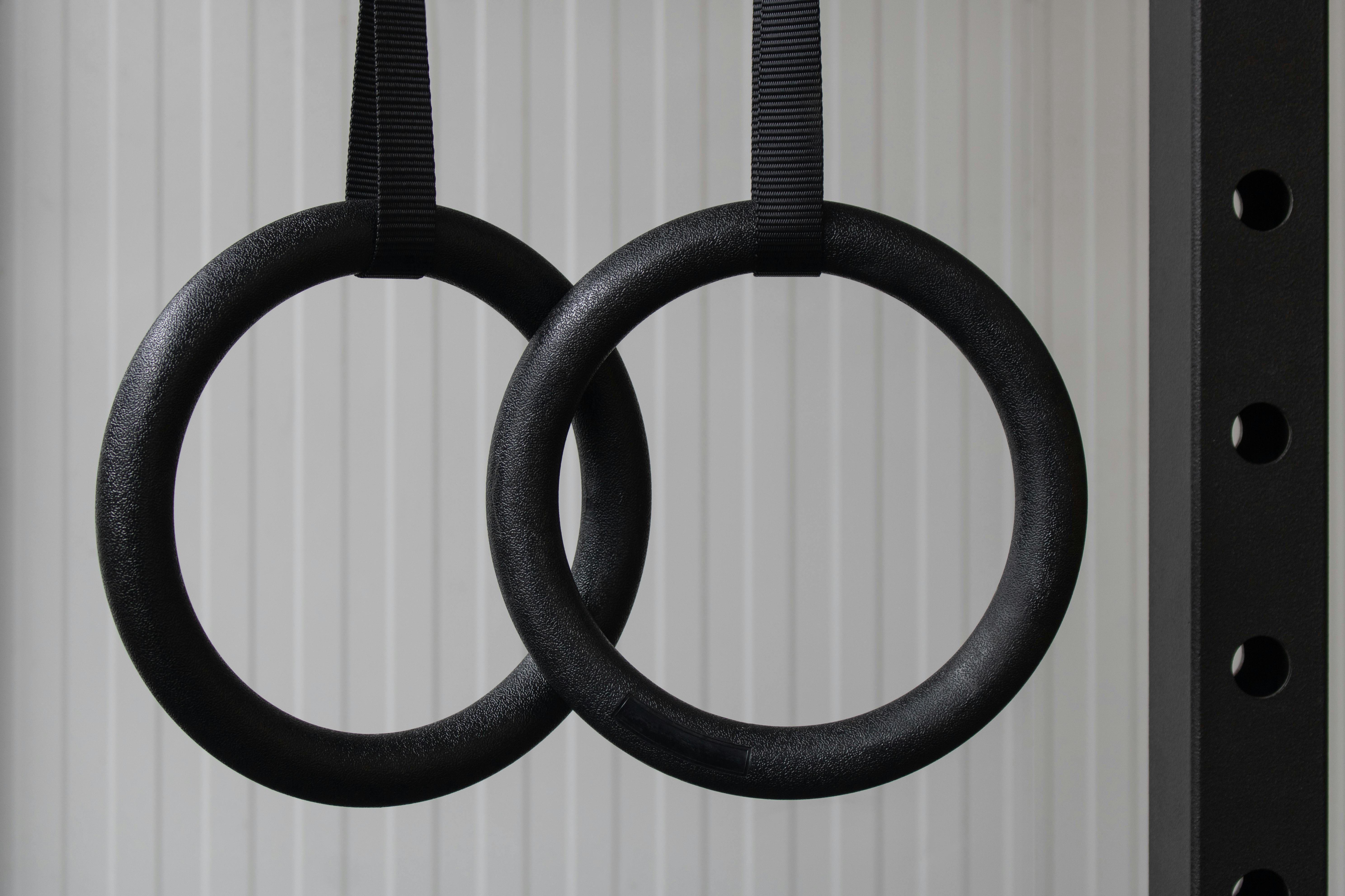 Closeup of set of black gymnastic rings or steady rings hanging in