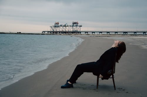 Man Leaning on Chair on Beach