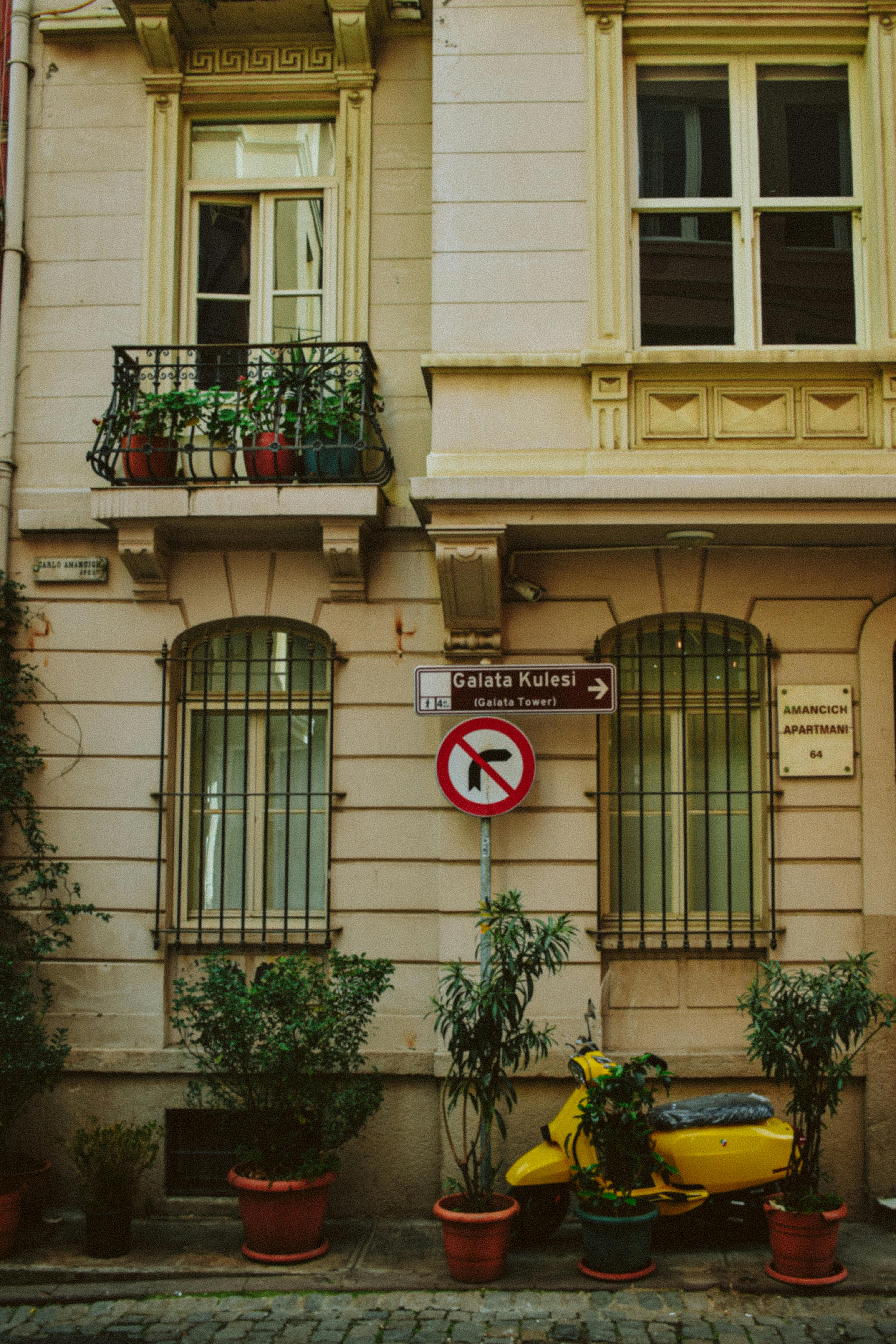 A picturesque street scene with plants and a sign to Galata Tower, Istanbul.