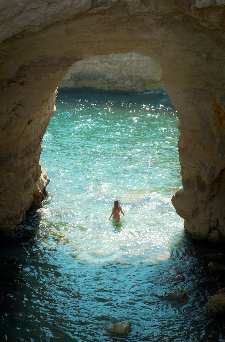 Woman In Water Near Cave