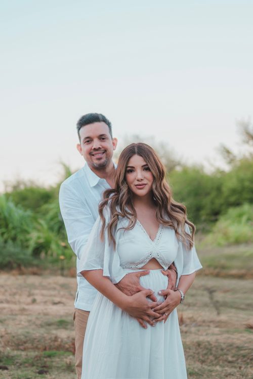 Free Elegant couple in a loving embrace, celebrating pregnancy outdoors. Stock Photo