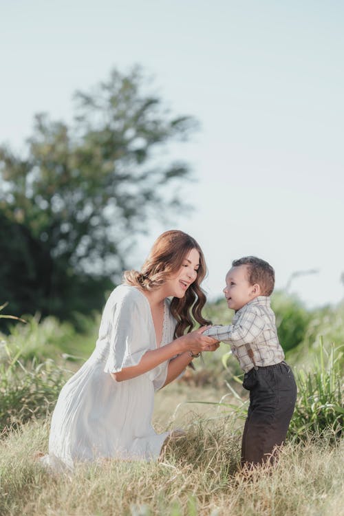 Smiling Mother Posing in White Dress with Son