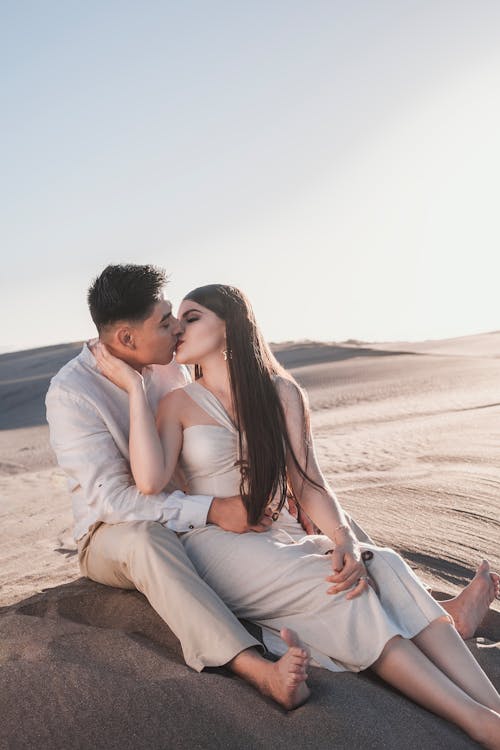 Couple Sitting and Kissing on Desert