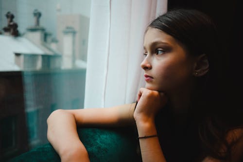 Girl Sitting by Window and Thinking