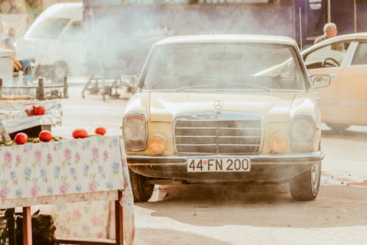 Vintage Mercedes in a lively street market, surrounded by smoke and vibrant colors