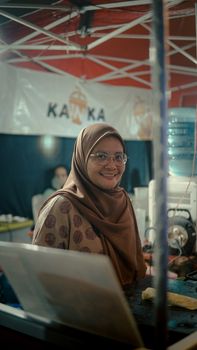 Woman in hijab smiling at a market stall in Serang, Banten, Indonesia. - Fotografer Sidoarjo