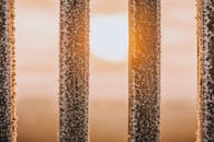 积雪覆盖的木栅栏在特写镜头下，点燃了温暖的冬日暮色