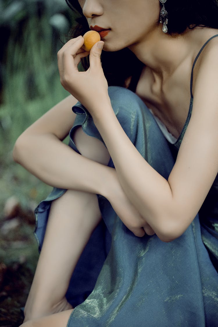 Woman Eating A Yellow Fruit