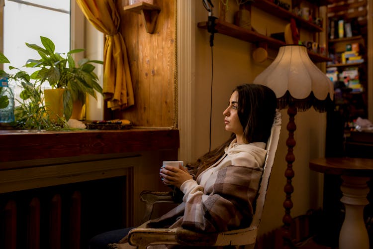 Woman Sitting And Posing On Armchair In Room