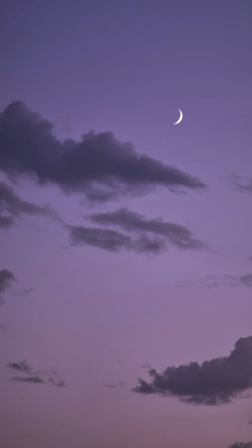 Crescent Moon among Dark Clouds at Dawn