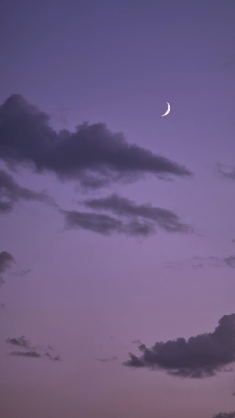 Crescent Moon Among Dark Clouds At Dawn