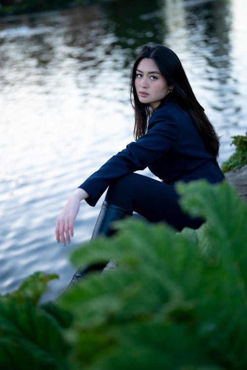 Free Model in Black Clothes Sitting by River Stock Photo