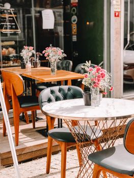 Charming outdoor cafe with elegant tables, chairs, and floral decorations.