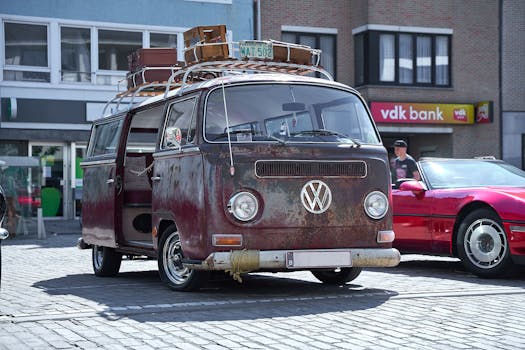 Rusty vintage Volkswagen van parked on street, showcasing its antique charm in an urban environment.