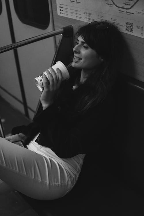 Woman Drinking Coffee in Subway in Black and White 