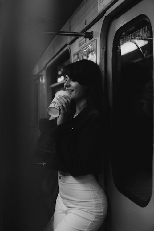 Smiling Woman Drinking on Metro Train