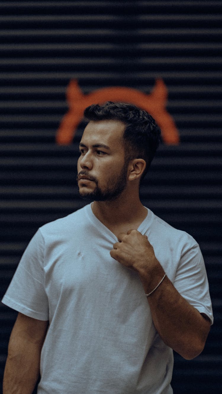 A Man Posing Against Red Horns Painted On A Wall