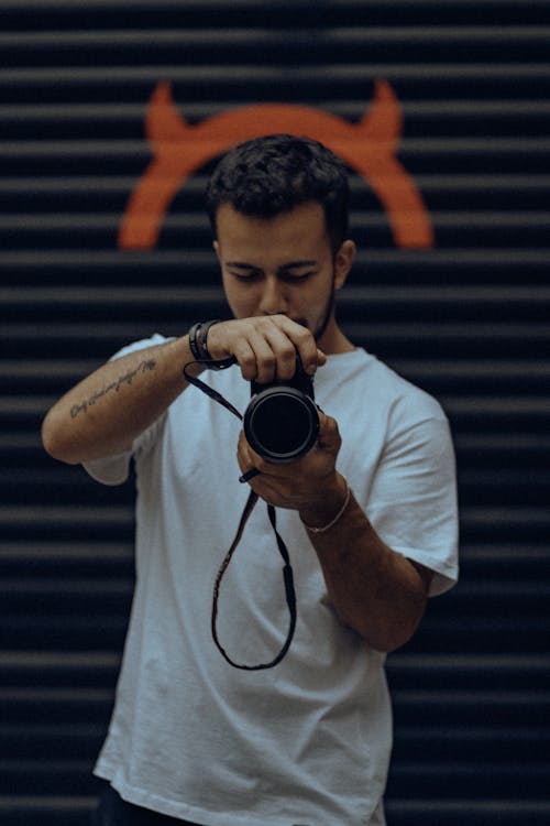 Foto profissional grátis de cabelo escuro, câmera, camiseta branca