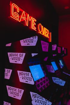 Vibrant arcade scene with neon 'Game Over' sign in CDMX, Mexico.