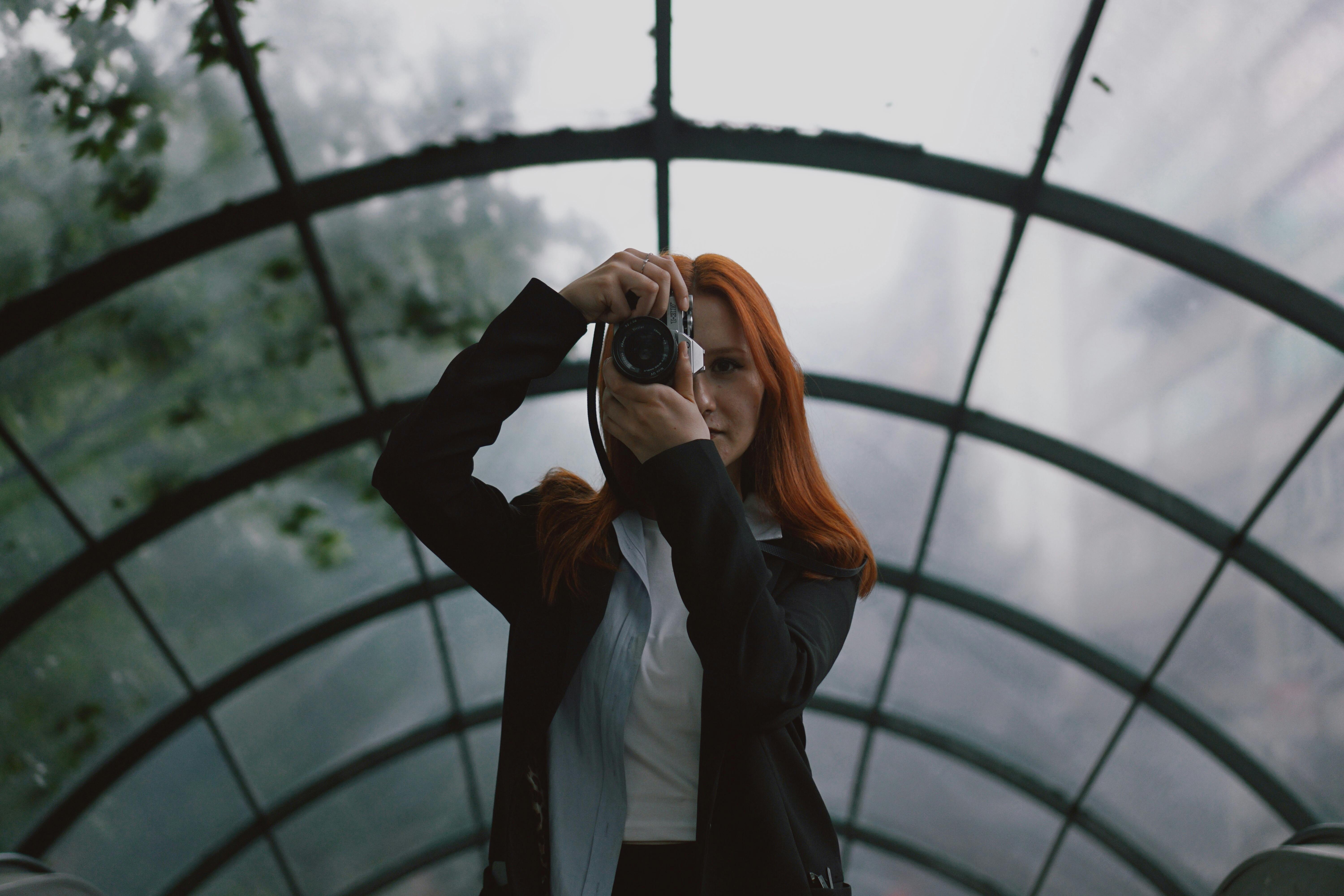 redhead woman taking pictures with camera