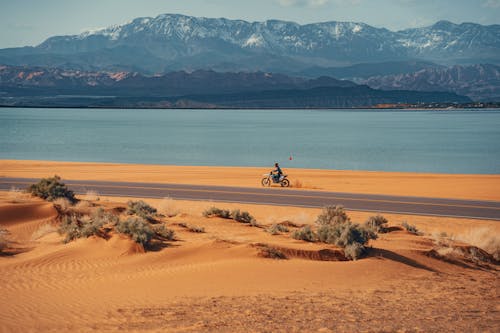 Riding Motocross on Desert by Road on Sea Coast