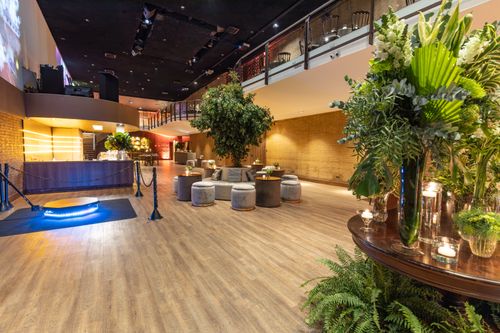 Free Spacious hotel lounge featuring modern furniture, plants, and a stylish bar, perfect for events or relaxation. Stock Photo