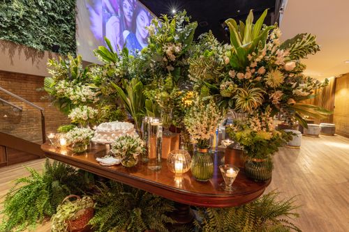 Free Opulent floral arrangements with candles on a wooden table, perfect for events or home decor inspiration. Stock Photo