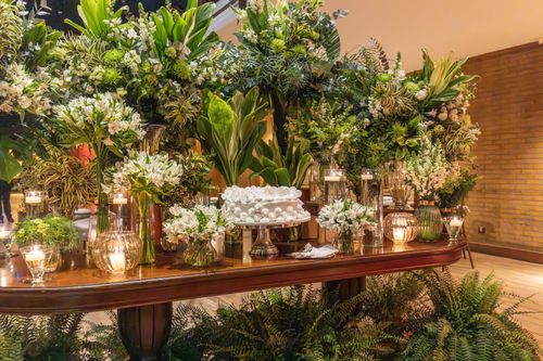Free Luxurious floral arrangement with candles and greenery on a polished wooden table, perfect for elegant events. Stock Photo