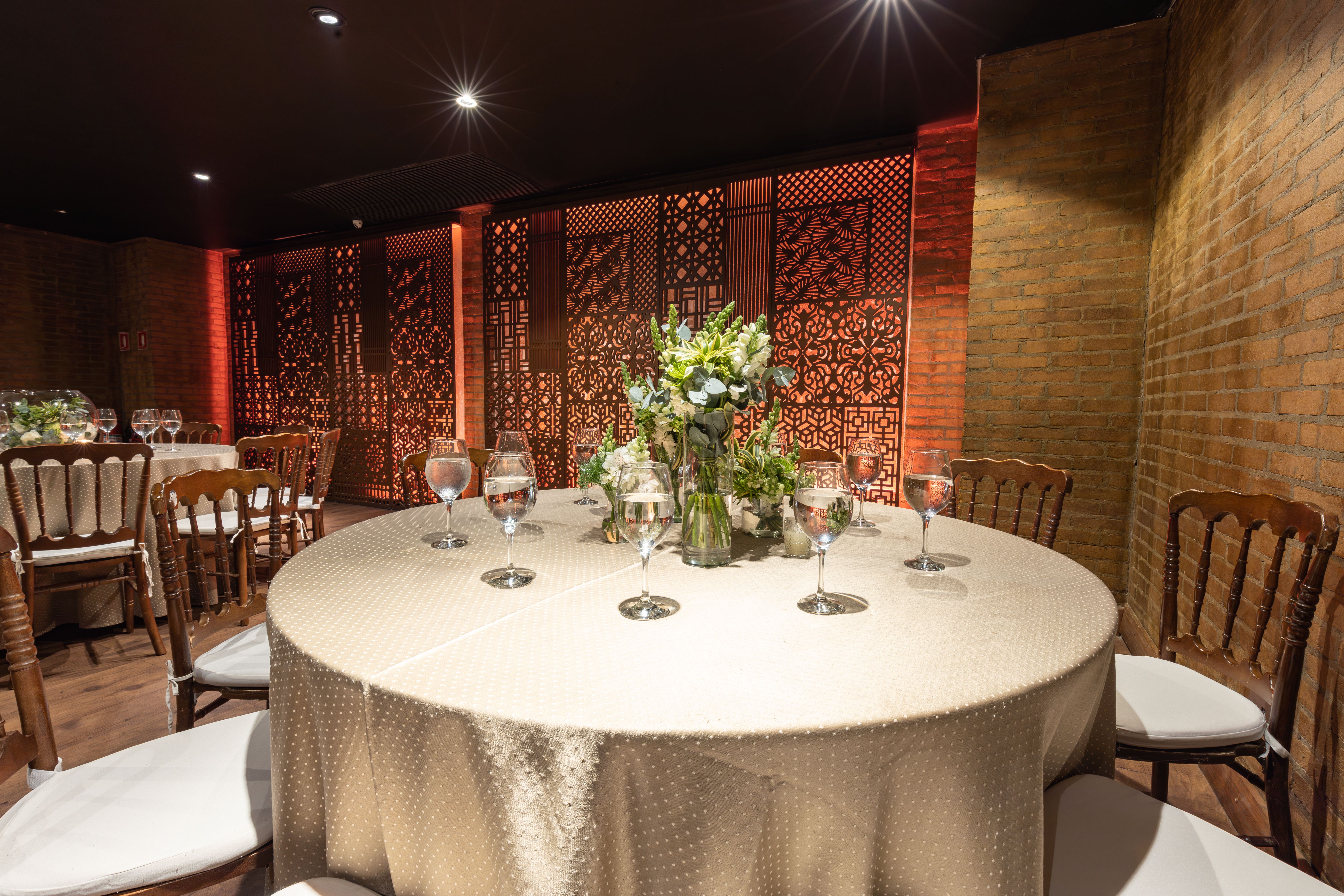 Luxurious wedding setting with chic floral arrangement, wine glasses, and ambient lighting.