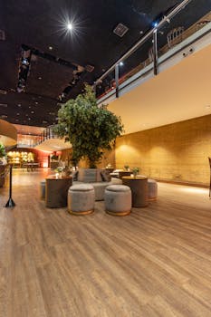 Elegant hotel lobby featuring modern decor, indoor tree, and cozy seating arrangement.