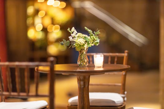 Elegant flowers in a glass vase on a wooden table with warm ambiance lighting.