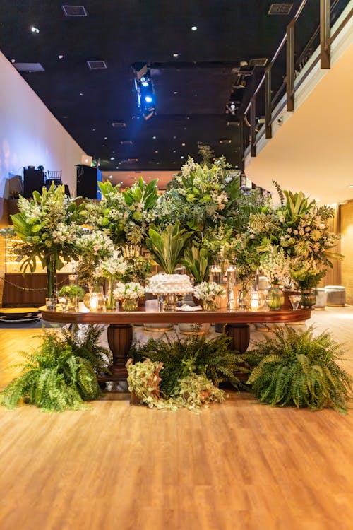 Cake on Table Decorated with Bouquets of Flowers Standing in Room