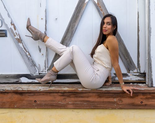 Brunette Woman in White Top Sitting on Wooden Step