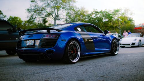 Free Elegant blue Audi sports car parked on a city street with people in the background. Stock Photo