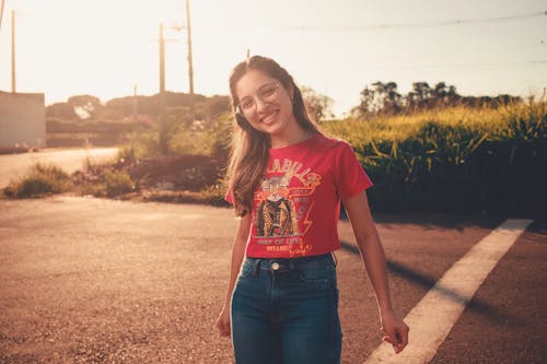 Young Woman in a T-Shirt Standing and Smiling in the Street 