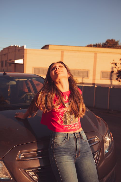 Smiling Woman Leaning on Car Bonnet