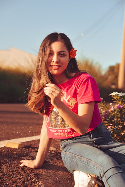 Young Woman in a Red T-Shirt and a Flower in her Hair 