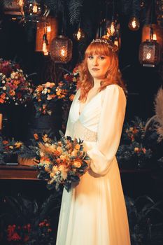 A redheaded bride holds a bouquet in an enchanting floral setting, perfect for wedding inspirations.