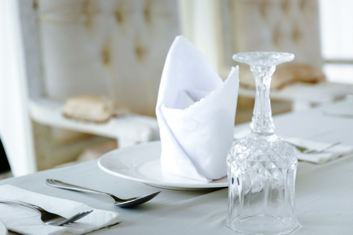 Diamond pocket folded napkin beside crystal glassware at a festive dinner